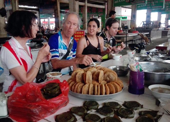 Tour guests are enjoying snacks in local market at Fuli town, a small place with ancient town near Yangshuo. 